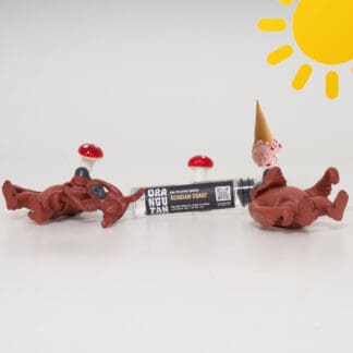 Orangutan Trading Co spore syringe with three toy orangutans playing with it, white background