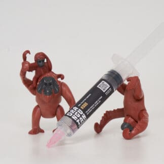 Orangutan Trading Co spore syringe with three toy orangutans playing with it, white background
