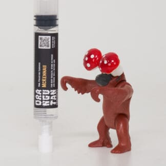 Orangutan Trading Co spore syringe with three toy orangutans playing with it, white background