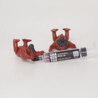 Orangutan Trading Co spore syringe with two toy orangutans playing with it, white background