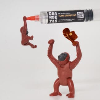 Orangutan Trading Co spore syringe with three toy orangutans playing with it, white background