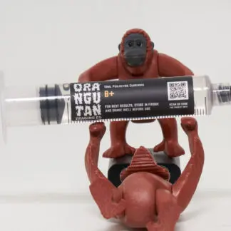 Orangutan Trading Co spore syringe with three toy orangutans playing with it, white background
