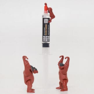 Orangutan Trading Co spore syringe with three toy orangutans playing with it, white background