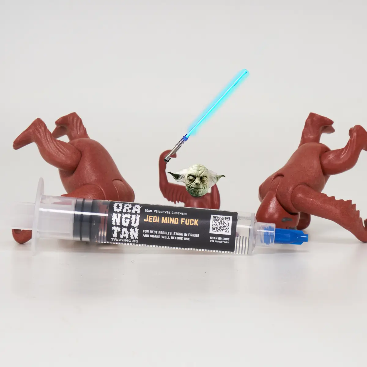 Orangutan Trading Co spore syringe with three toy orangutans playing with it, white background